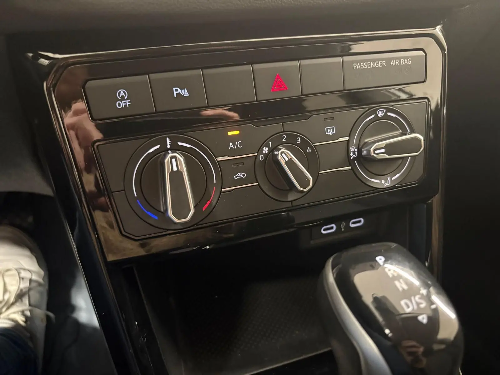 Vue rapprochée de la console centrale noire avec commandes de climatisation manuelle et levier de vitesse automatique du Volkswagen T-Cross.