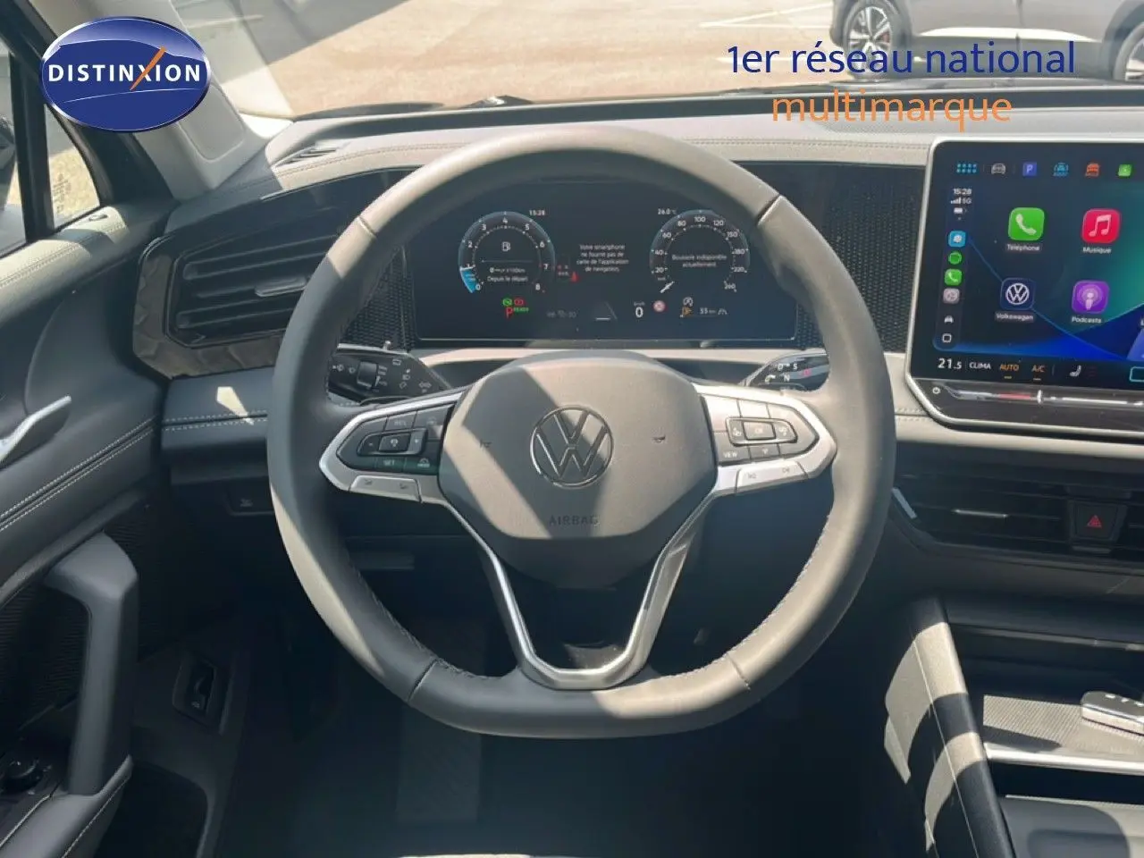 Vue intérieure centrée sur le volant noir du Volkswagen Tiguan 1.5 TSI 130ch avec tableau de bord numérique et écran tactile.