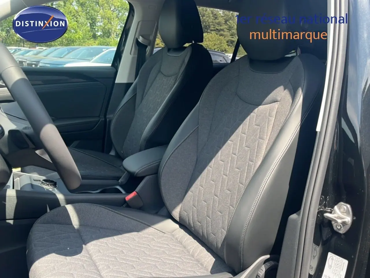 Vue intérieure côté avant droit du Volkswagen Tiguan noir Grenadilla, mettant en valeur les sièges tissu et cuir gris.