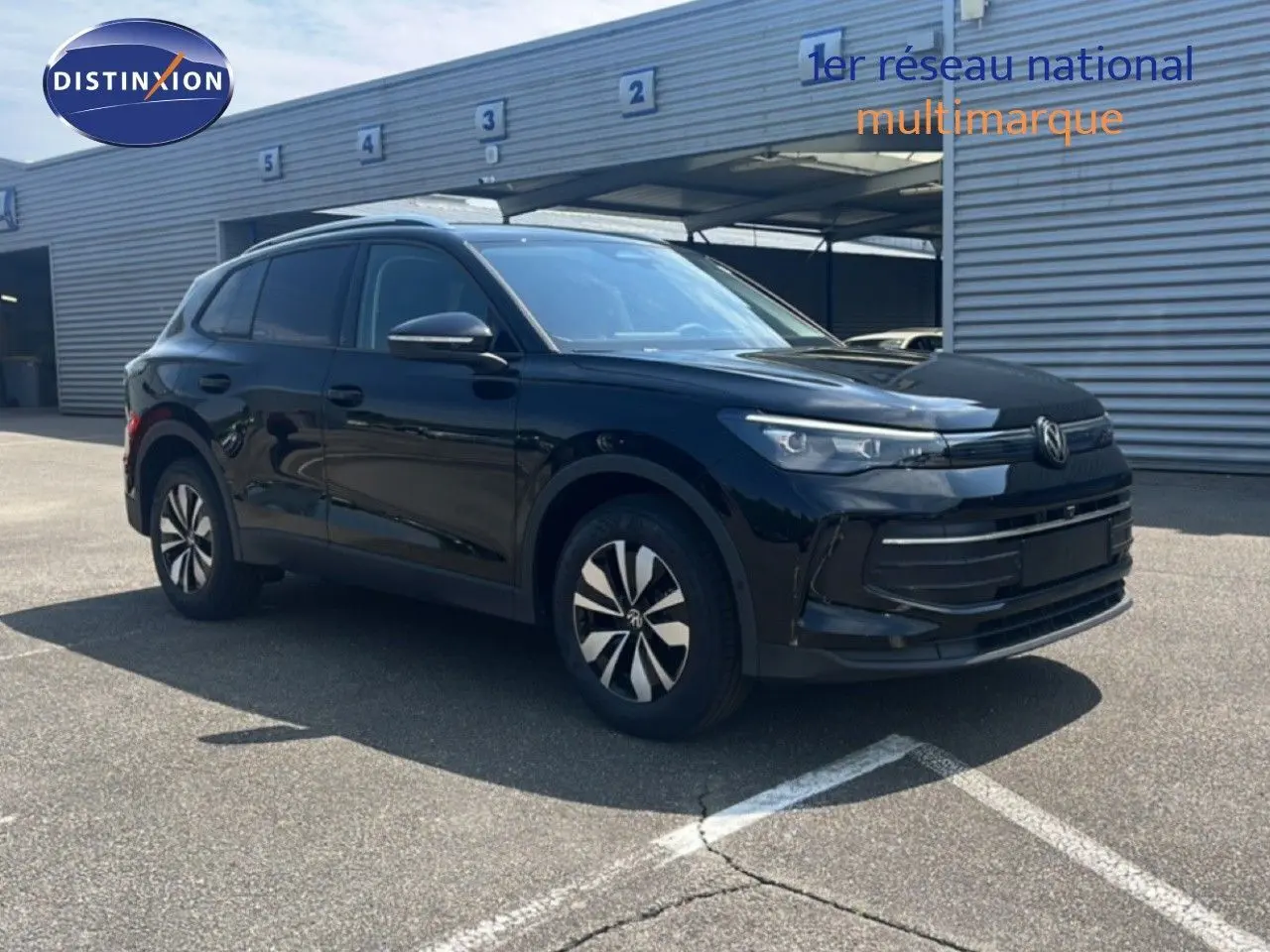 Volkswagen Tiguan noir Grenadilla métal en 3/4 avant droit, avec jantes bi-ton et calandre moderne.