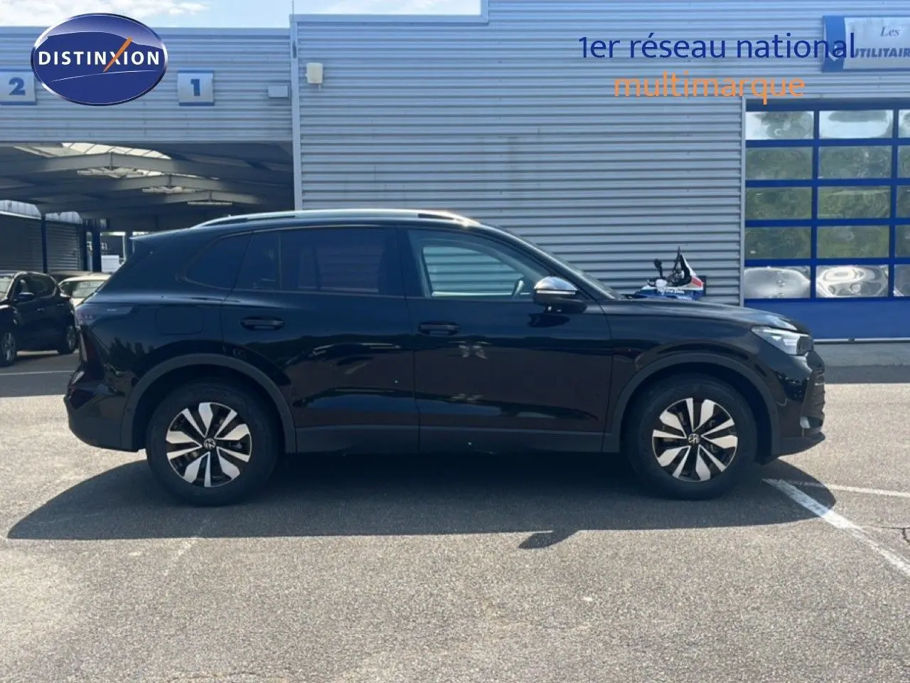 Vue latérale droite du Volkswagen Tiguan noir Grenadilla 2026, SUV compact avec jantes alliage distinctives.