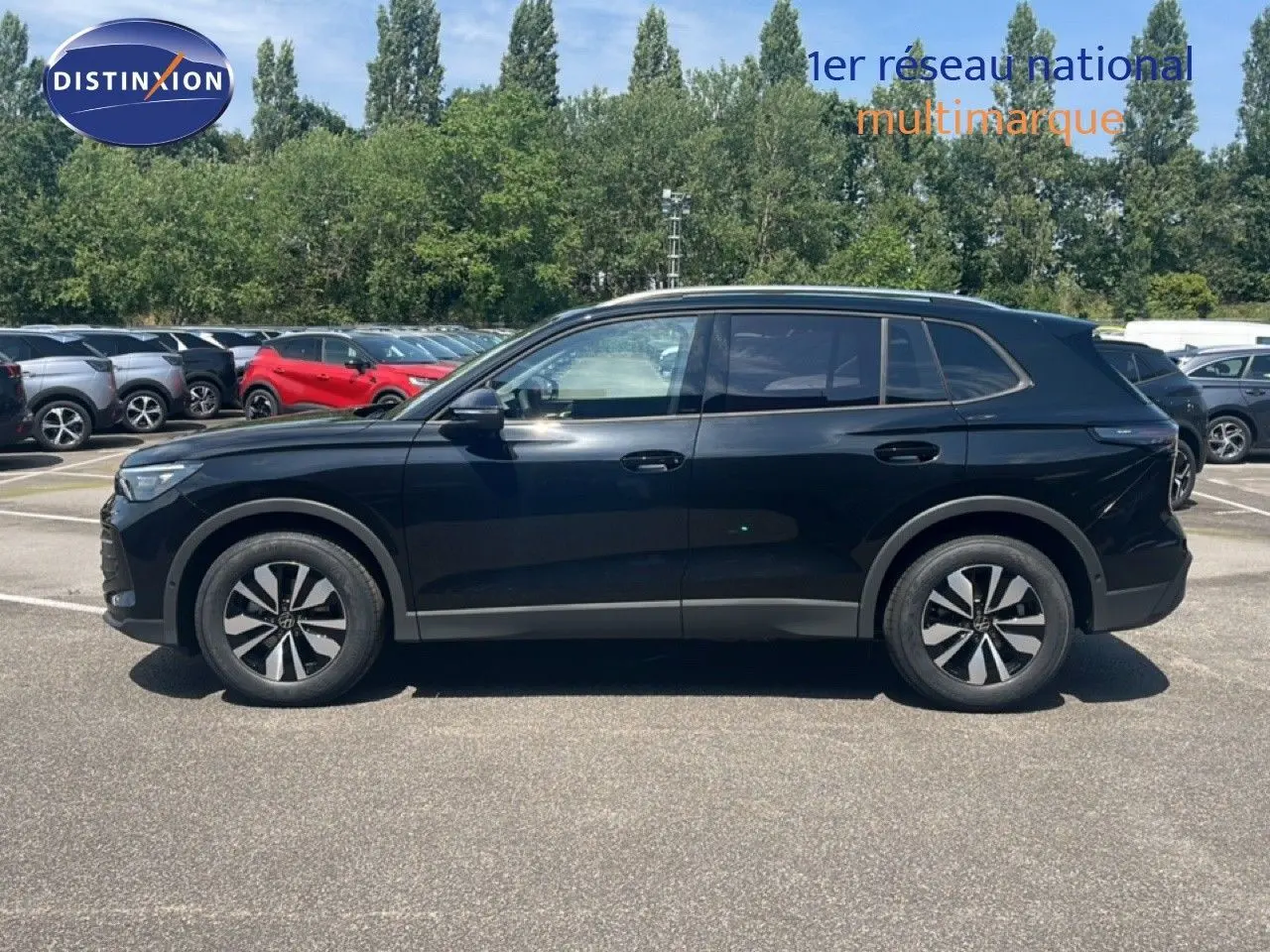 Profil latéral droit du Volkswagen Tiguan noir Grenadilla métallisé, avec jantes alliage et lignes épurées visibles.