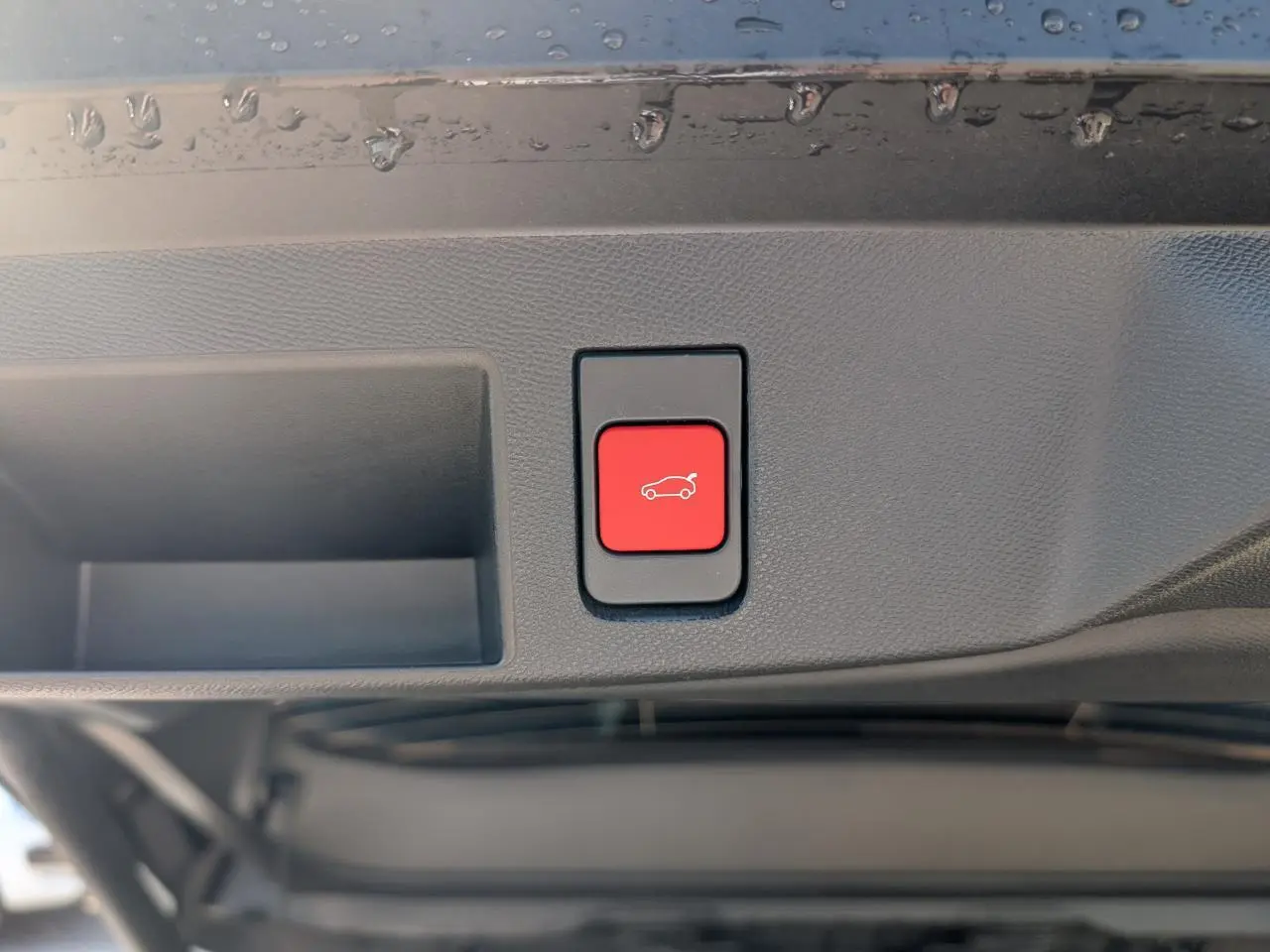 Bouton rouge d'ouverture électrique du hayon sur la partie intérieure d'un Citroën C5 Aircross blanc.