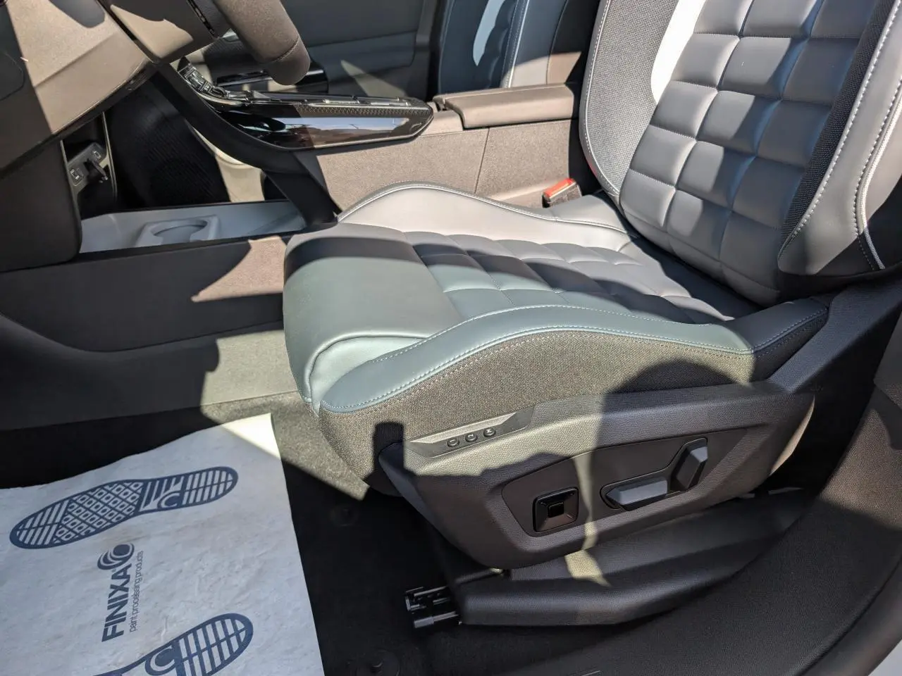 Gros plan sur le siège conducteur avant droit en cuir noir avec réglages électriques dans l'habitacle du Citroën C5 Aircross blanc.