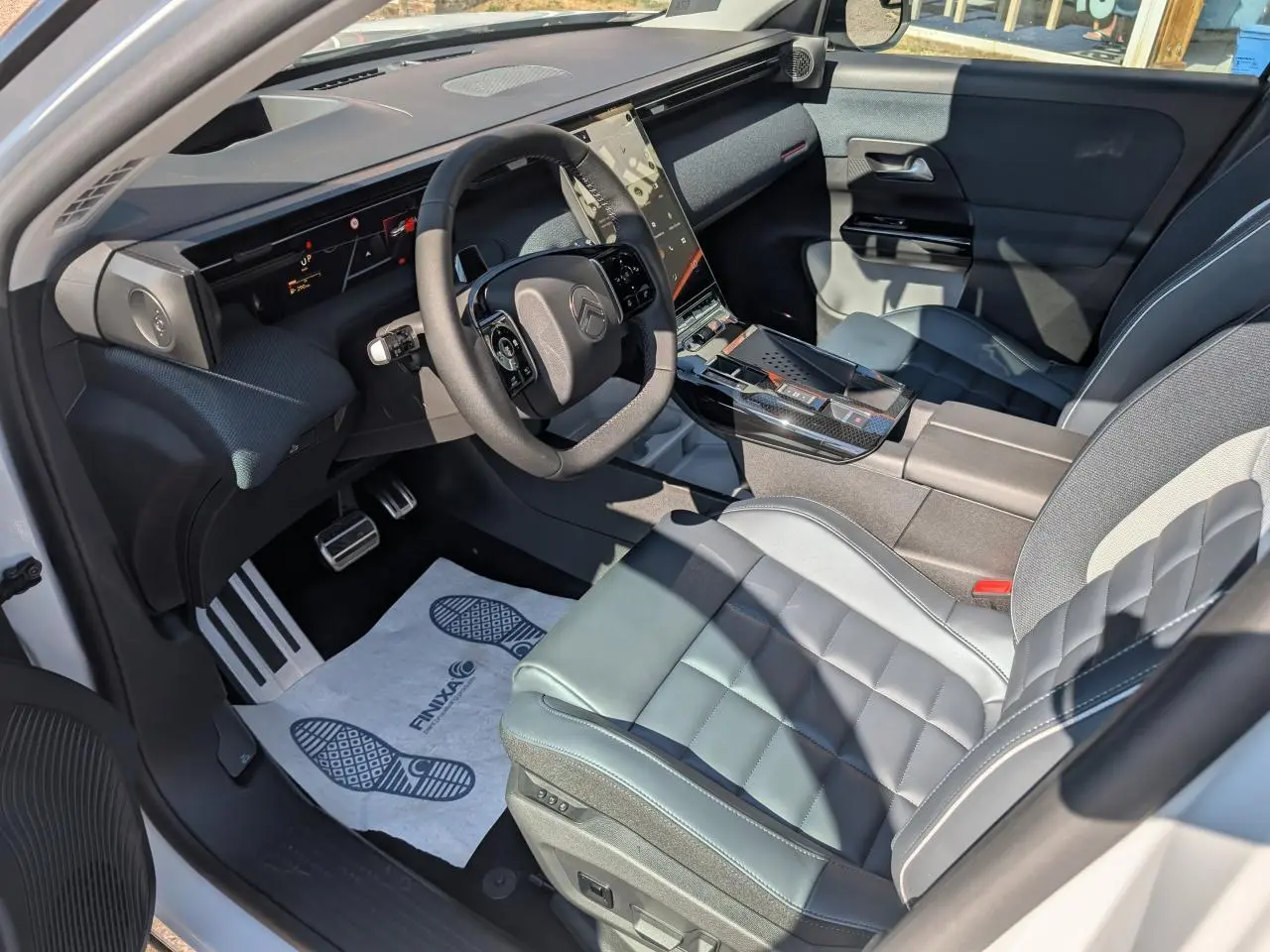 Vue intérieure côté conducteur du Citroën C5 Aircross blanc, avec sellerie cuir et tableau de bord moderne noir.