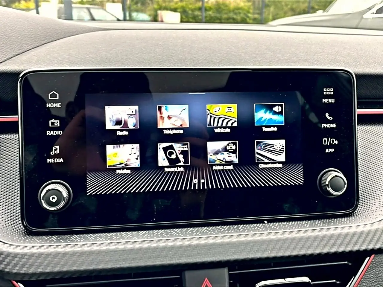 Écran tactile central du Skoda Kamiq blanc nacré 2026 avec interface multimédia et commandes autour.