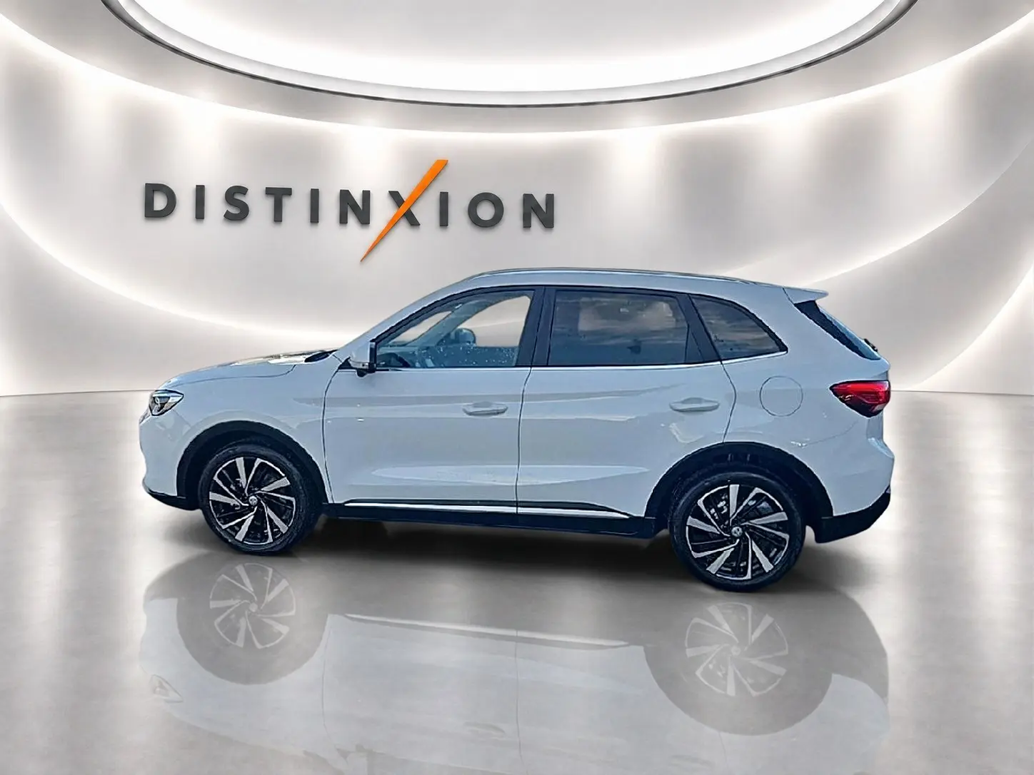 Vue de profil côté gauche du MG ZS blanc 2026 hybride, avec jantes alliage et toit panoramique en arrière-plan lumineux.