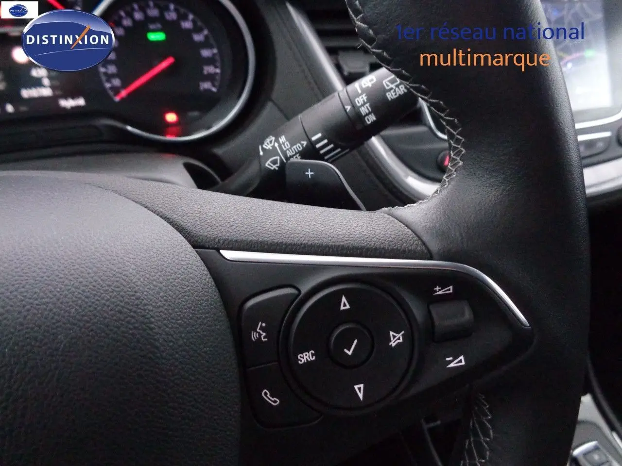 Gros plan sur les commandes au volant en cuir noir de l'Opel Grandland X hybride rechargeable blanc nacré de 2021.