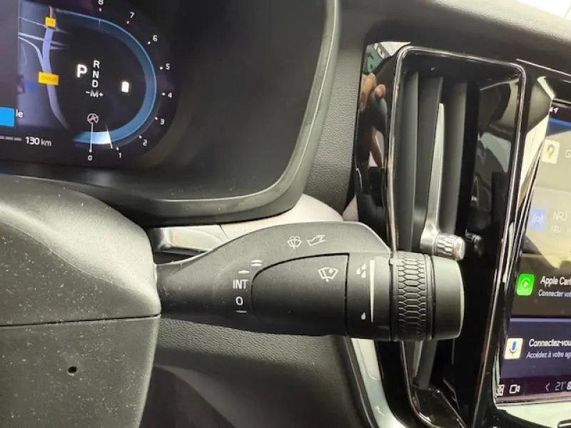 Gros plan sur la commande d'essuie-glace à l'intérieur d'un Volvo S60 2024, avec tableau de bord numérique et écran tactile visible.