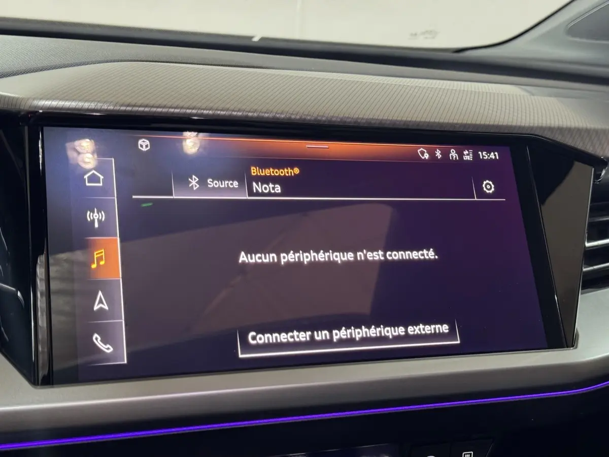 Écran tactile central allumé dans l'habitacle de l'Audi Q4 E-TRON Design Luxe 2022, ambiance lumineuse violette.