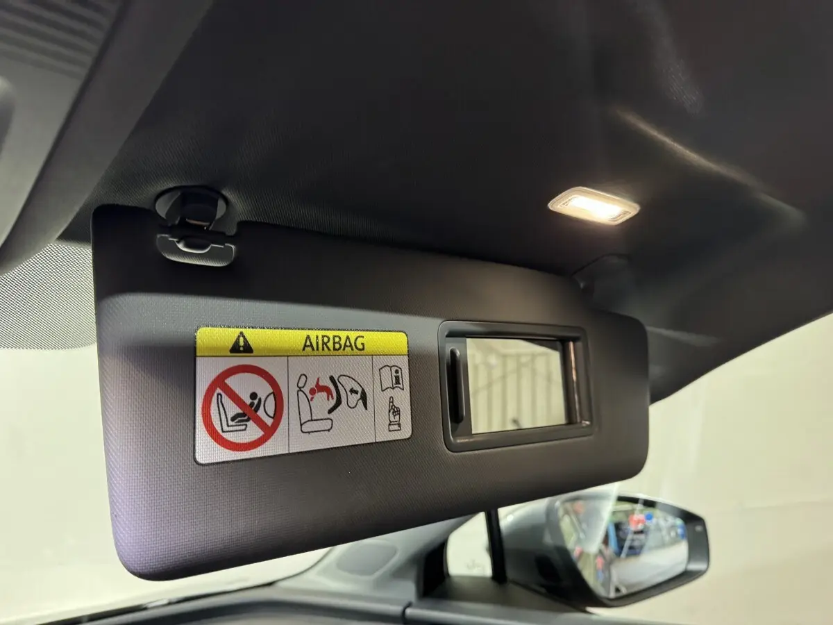 Détail du pare-soleil côté conducteur avec miroir et avertissement airbag dans un Audi Q4 E-TRON gris foncé 2022