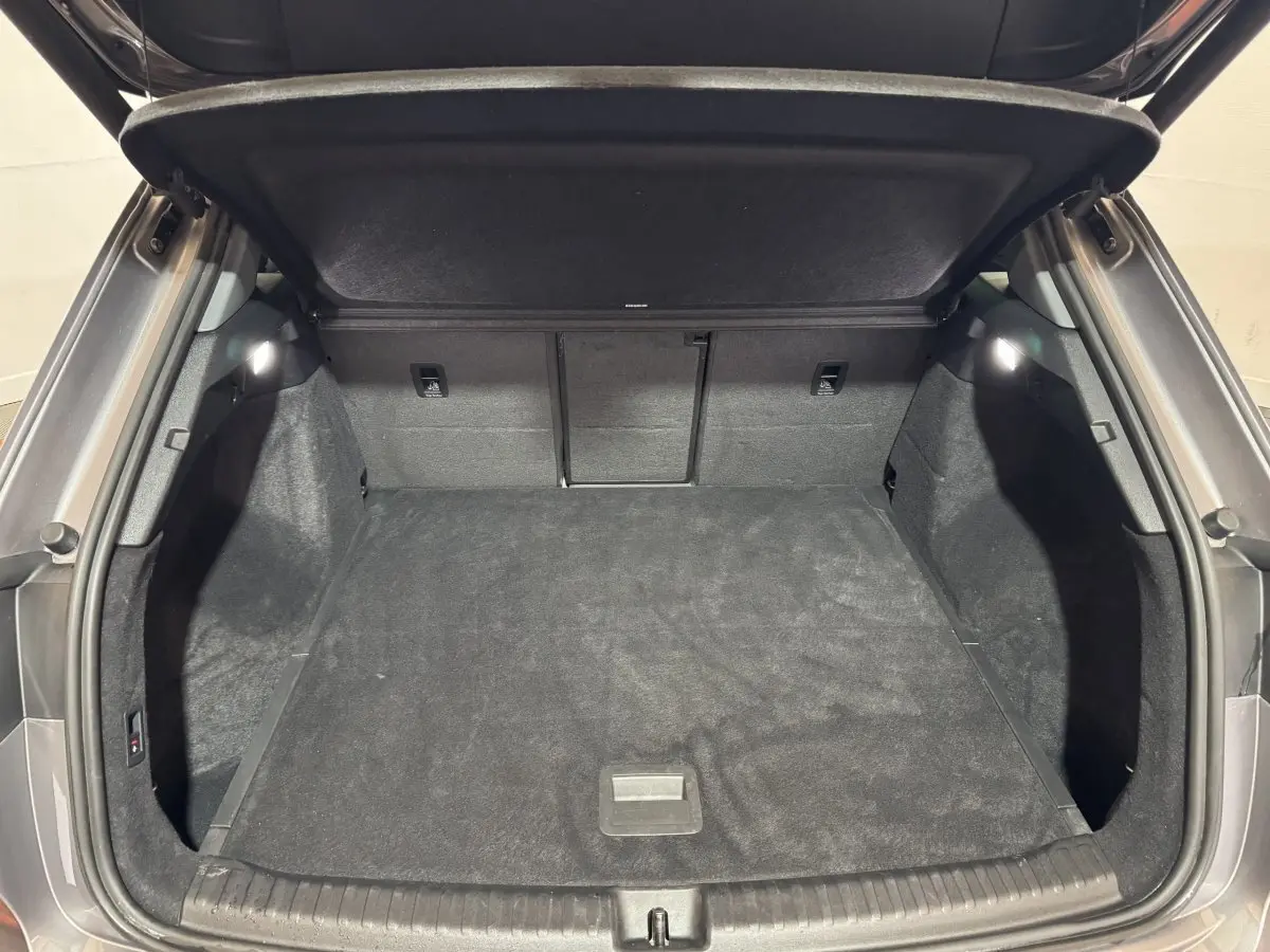 Coffre ouvert gris foncé de l'Audi Q4 E-TRON 50 quattro 2022, intérieur spacieux et tapis noir.
