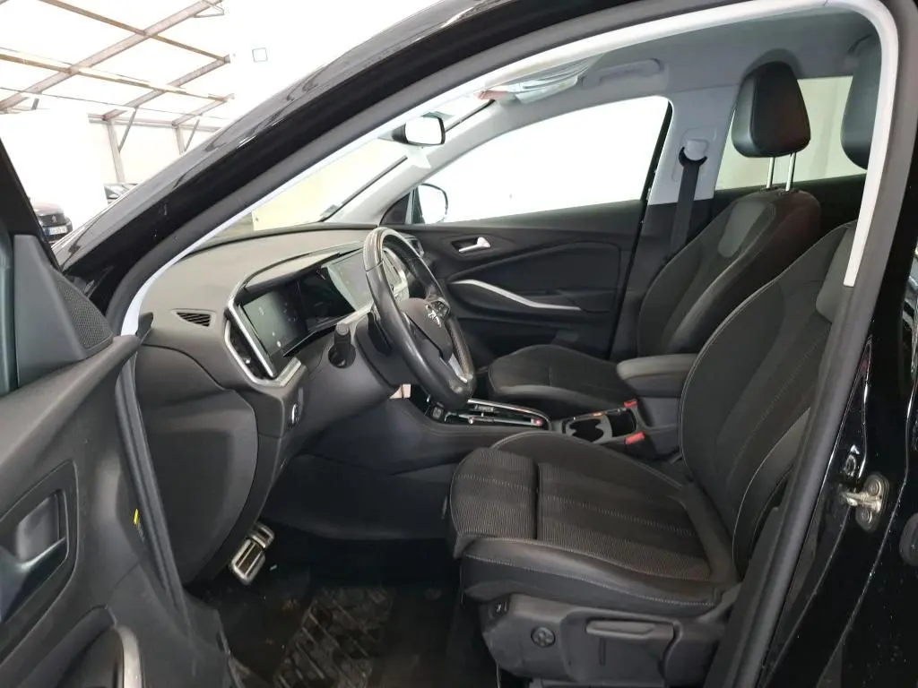 Vue 3/4 arrière droite d'un Opel Grandland noir 2023 avec jantes alliage bicolores et vitres teintées.