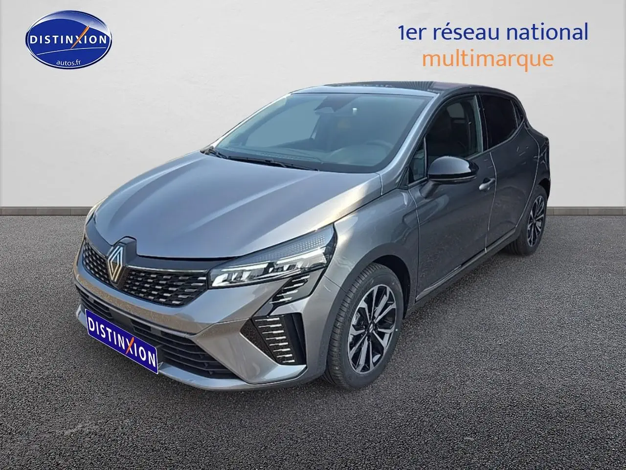 Renault Clio V gris schiste vue 3/4 avant droit, mettant en valeur sa calandre chromée et ses phares LED distinctifs.
