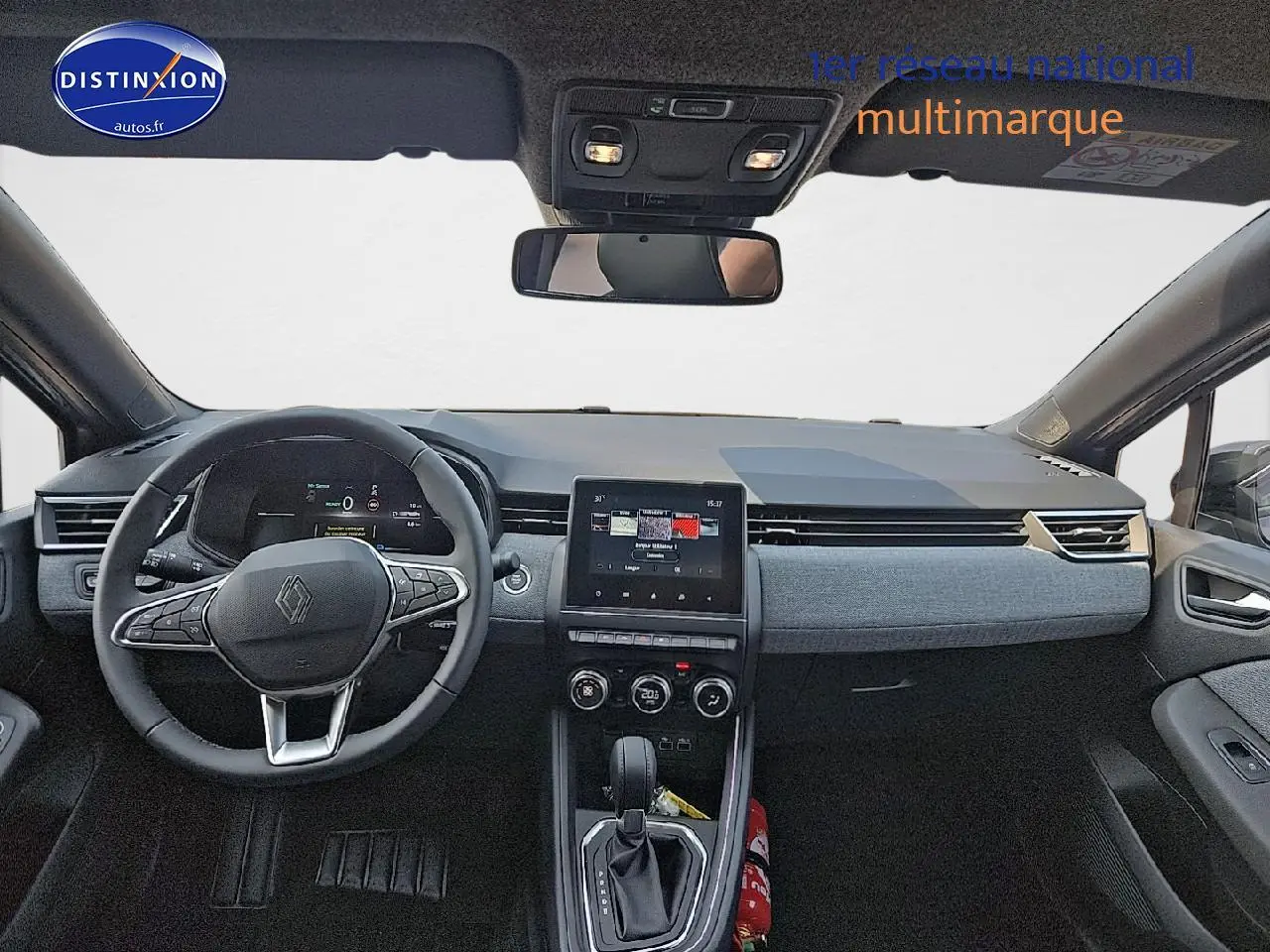 Vue intérieure avant de la Renault Clio V 1.6 e-tech 145 techno, tableau de bord gris avec écran tactile central et volant multifonction.