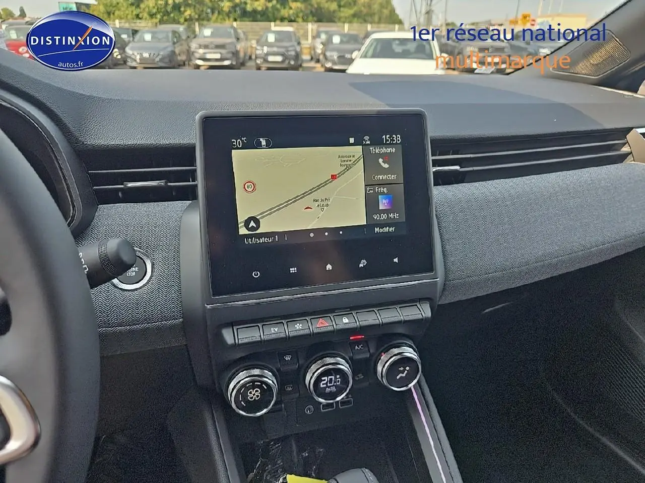 Vue intérieure centrée sur la console centrale et l'écran tactile du tableau de bord de la Renault Clio V gris schiste.