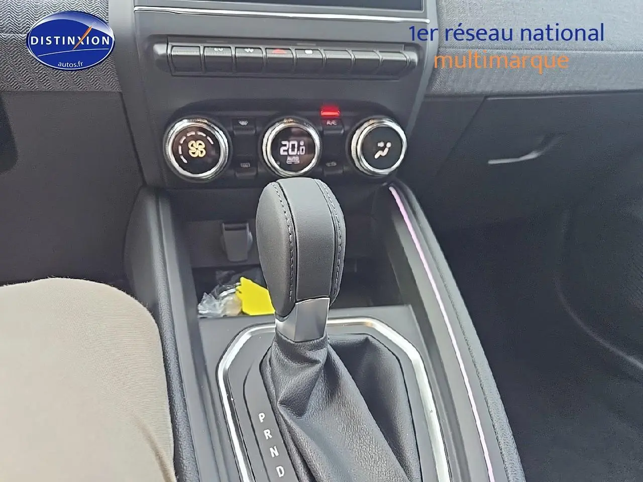 Le levier de vitesse automatique noir de la Renault Clio V 1.6 e-tech 145 techno vu de dessus avec commandes de climatisation.