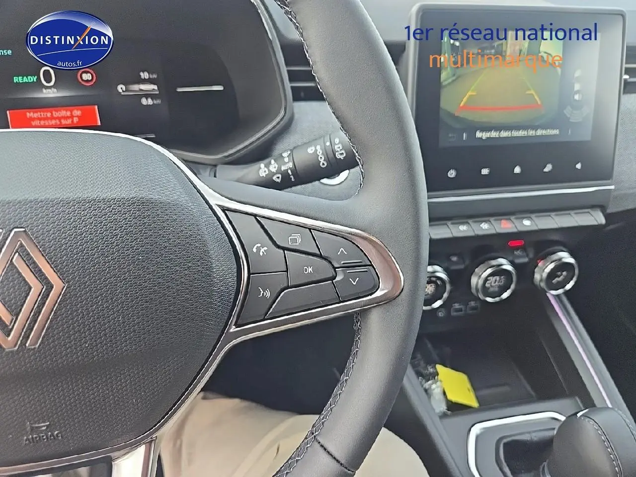 Vue intérieure centrée sur le volant multifonction et l'écran tactile du tableau de bord de la Renault Clio V gris schiste.