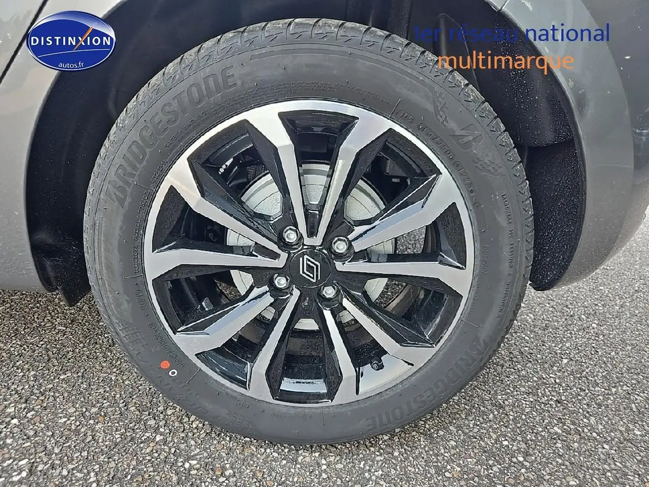 Gros plan sur la jante alu bicolore avec logo Renault d'une Renault Clio V gris schiste, vue côté droit.