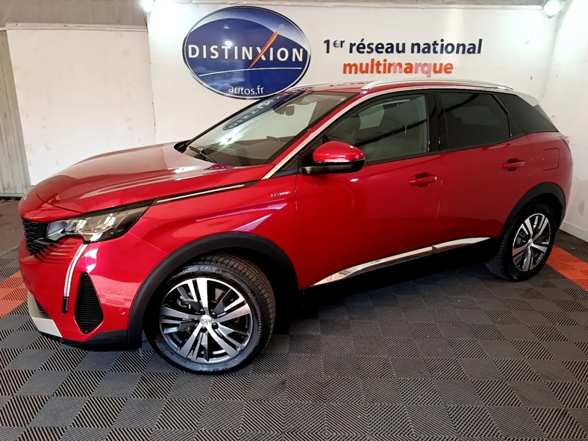 Vue 3/4 avant droit d’un Peugeot 3008 hybride rechargeable rouge avec jantes alliage et détails chromés sur fond intérieur showroom.