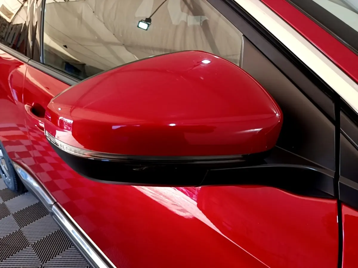 Rétroviseur droit rouge brillant du Peugeot 3008 1.6 Hybrid 225, vue rapprochée côté conducteur.