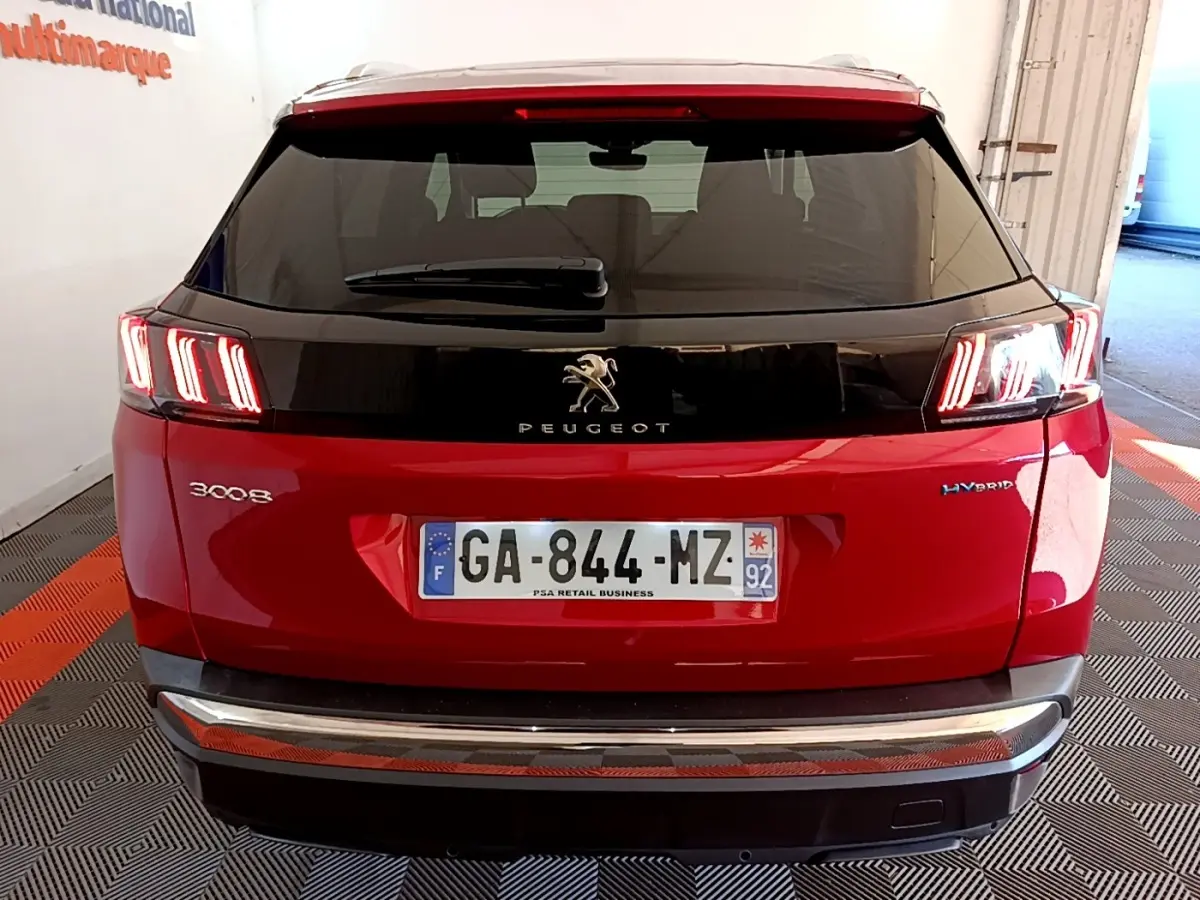 Vue arrière d’un Peugeot 3008 hybride rechargeable rouge avec feux LED caractéristiques et toit noir brillant.