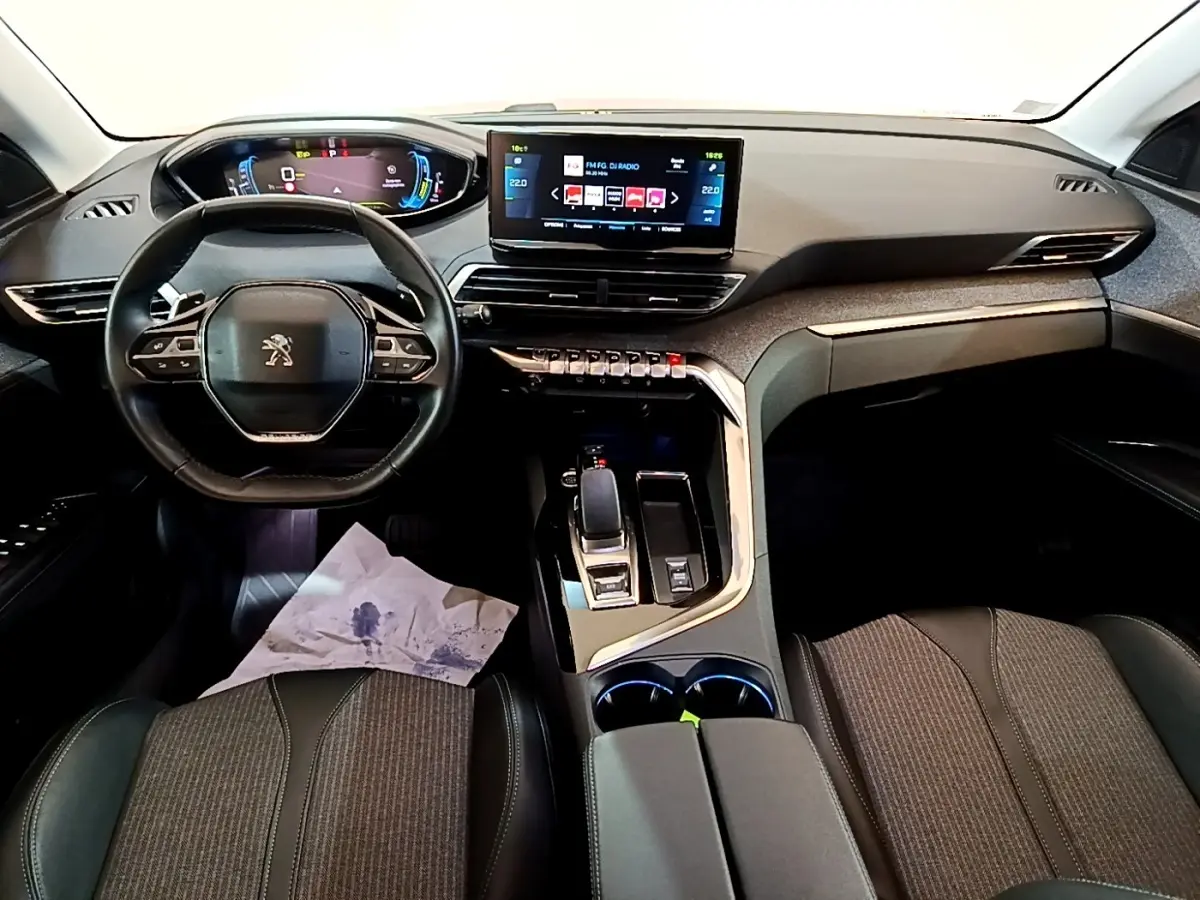 Vue intérieure avant du tableau de bord et volant cuir noir du Peugeot 3008 hybride rechargeable avec écran tactile central.