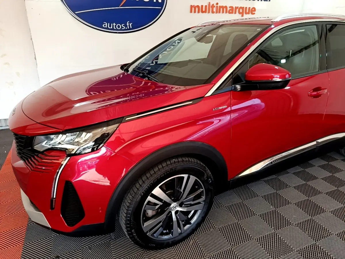 Vue 3/4 avant droit d’un Peugeot 3008 hybride rechargeable rouge avec jantes alliage et détails chromés.