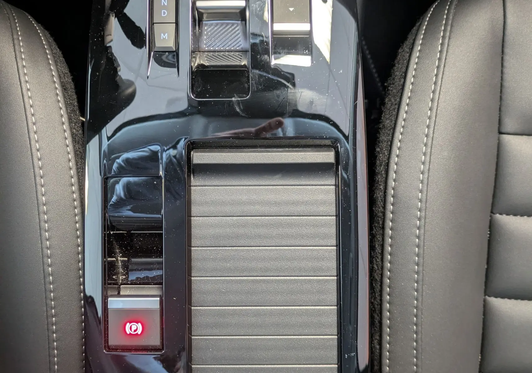 Vue plongeante sur la console centrale noire brillante de la Citroën C4 1.2 Hybride avec sélecteur de boîte automatique et bouton Drive Mode.