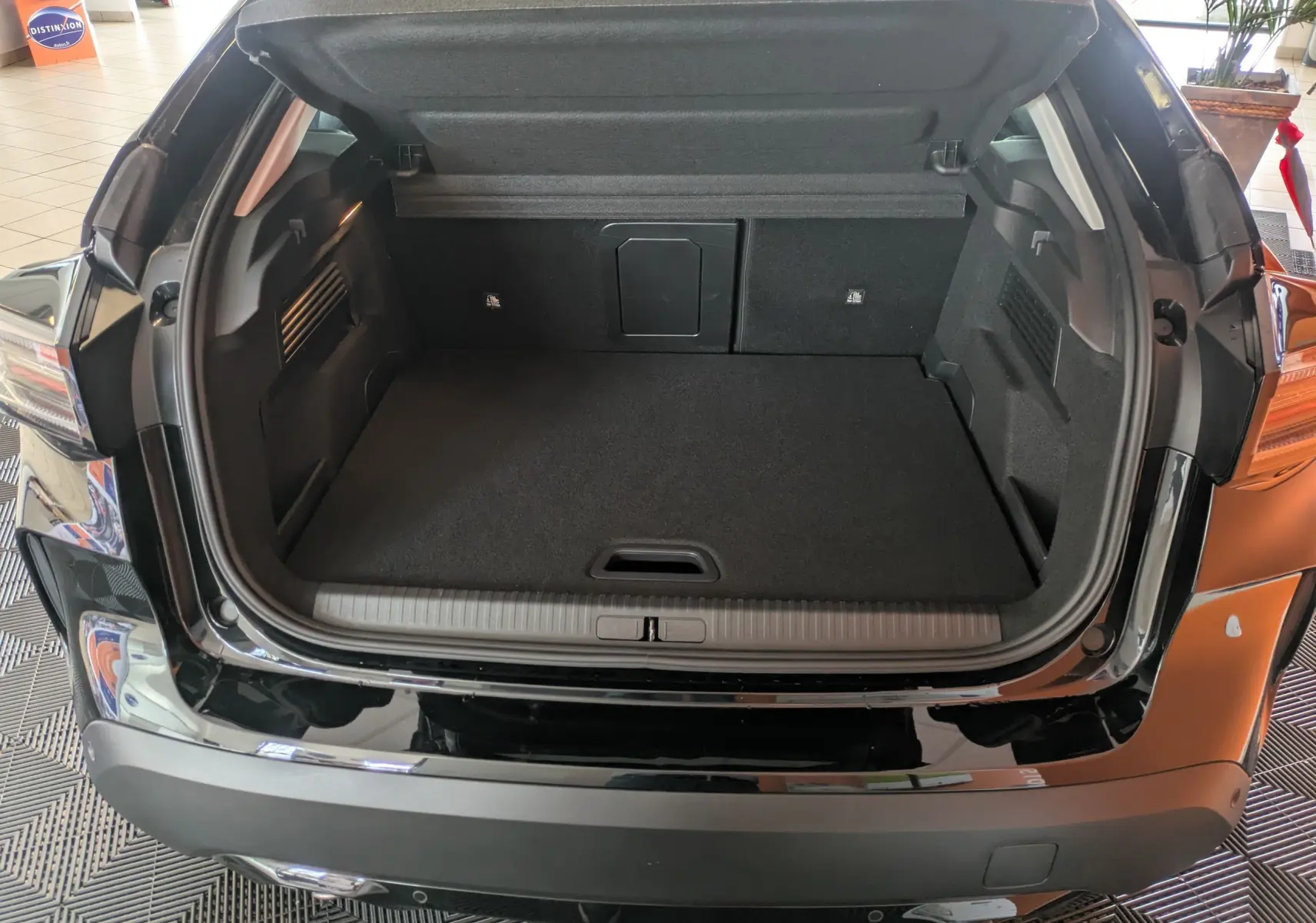 Coffre ouvert vu de l'arrière d'une Citroën C4 noire 2025, montrant un espace de chargement propre et spacieux.