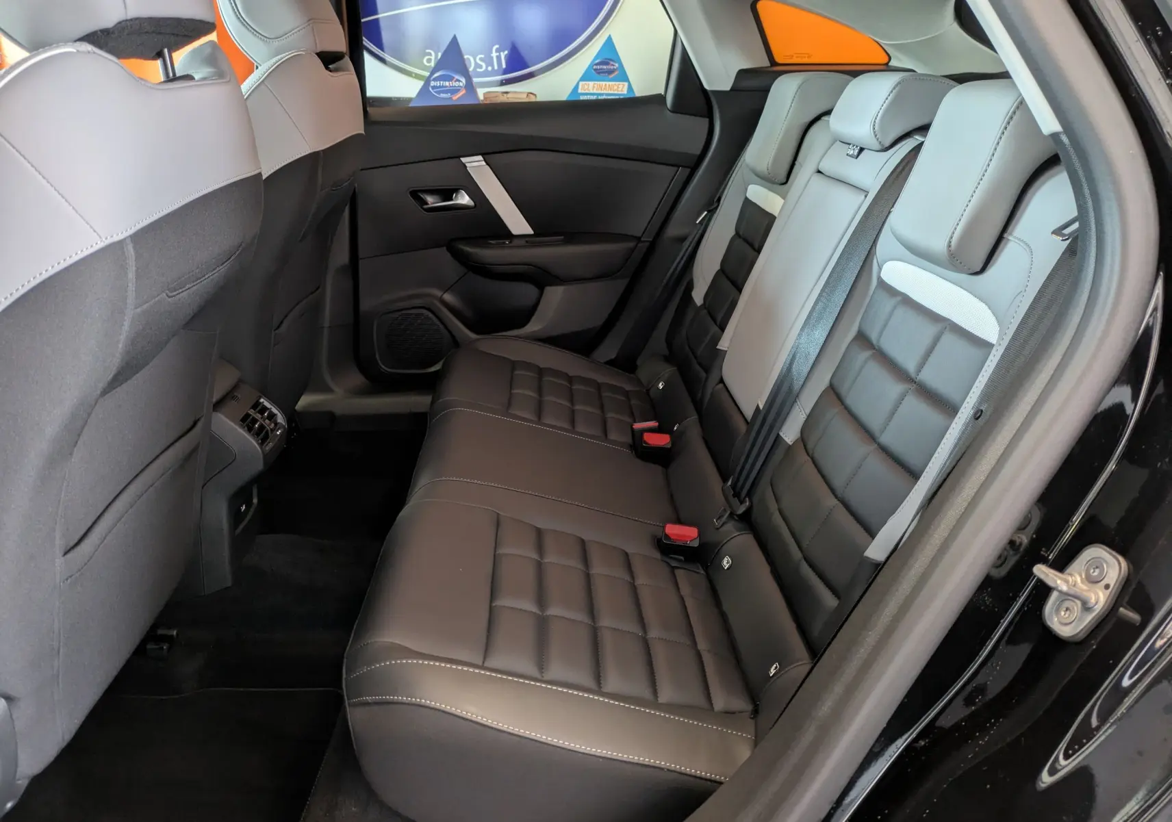 Vue intérieure côté droit des sièges arrière en cuir noir et gris de la Citroën C4 1.2 Hybride 2025.