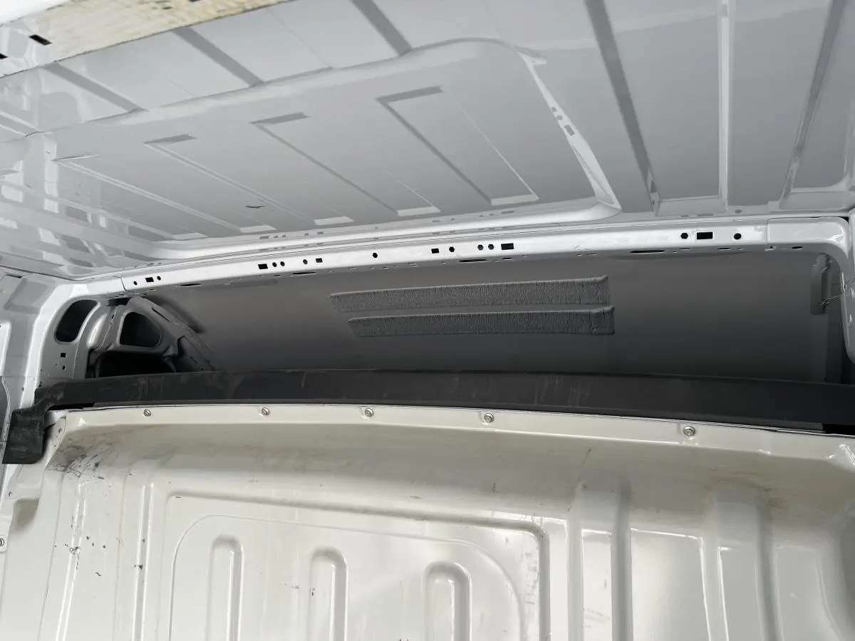 Vue intérieure arrière du Peugeot Boxer Fourgon blanc montrant la cloison tôlée et le plafond du compartiment de chargement.