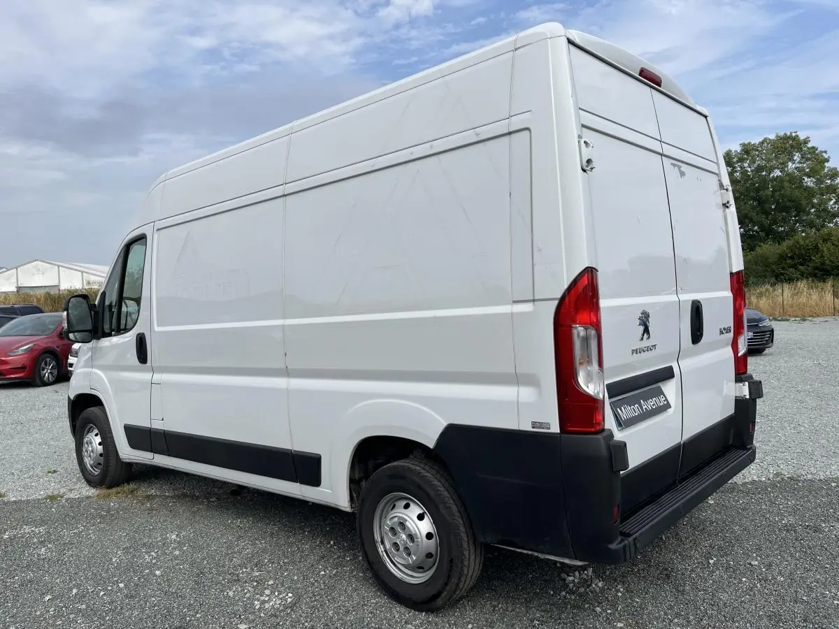 Vue 3/4 arrière droit d’un Peugeot Boxer Fourgon blanc avec portes arrière tôlées et porte latérale coulissante.