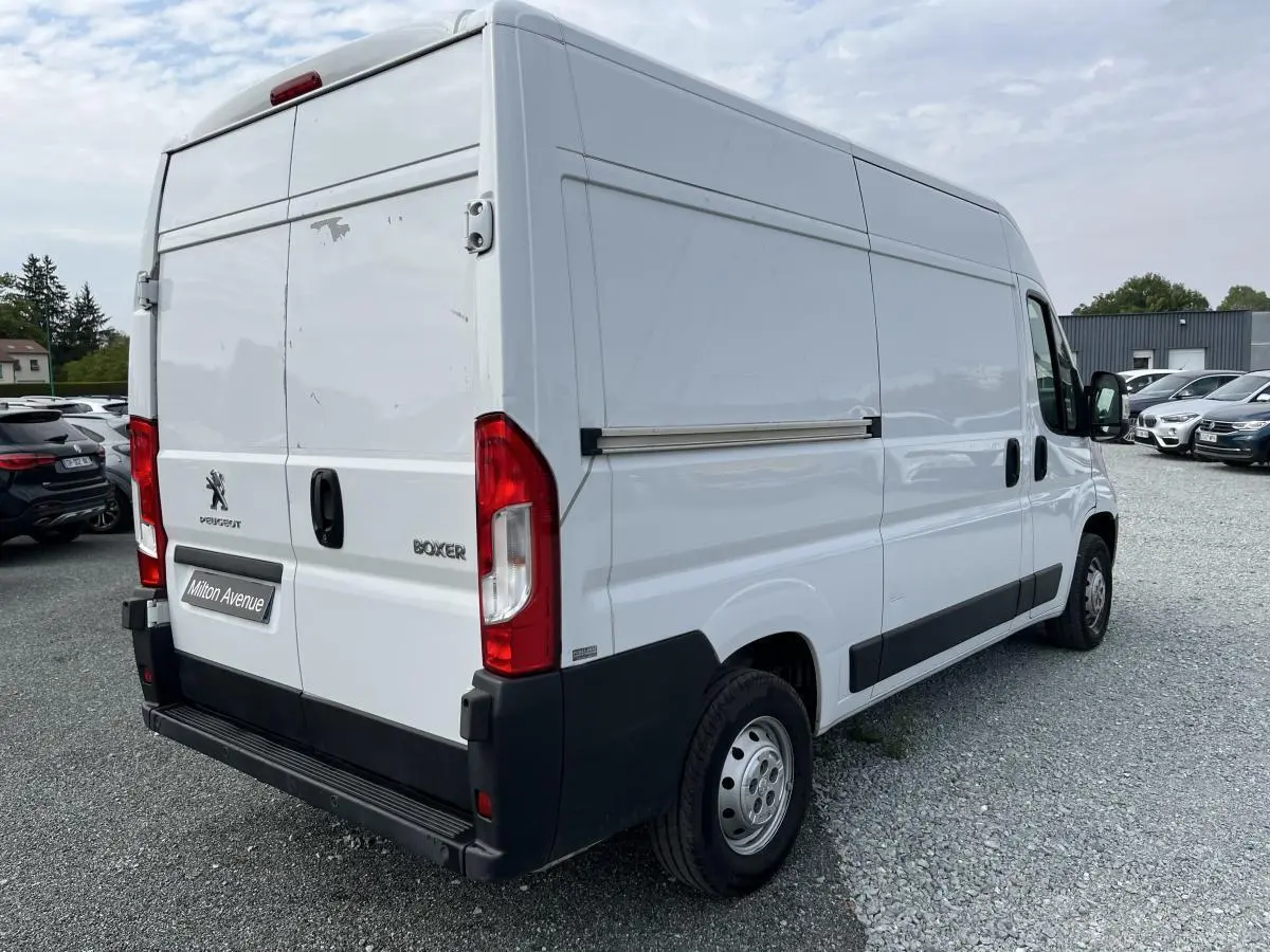 Vue 3/4 arrière droite d’un Peugeot Boxer Fourgon blanc avec portes arrière tôlées et porte latérale coulissante.