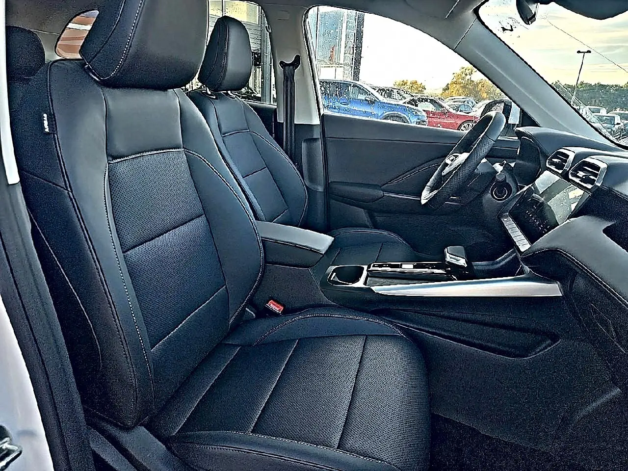 Vue intérieure côté conducteur du MG ZS 1.5 hybrid 197 luxury 2026 avec sièges noir simili-cuir et console centrale moderne.