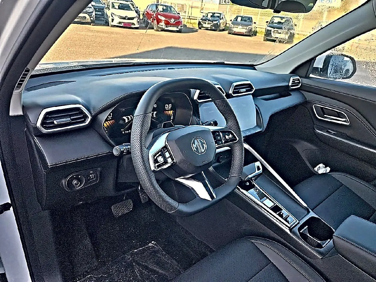 Intérieur noir du MG ZS 1.5 hybrid 197 luxury vu côté conducteur, avec volant multifonction et écran tactile central.