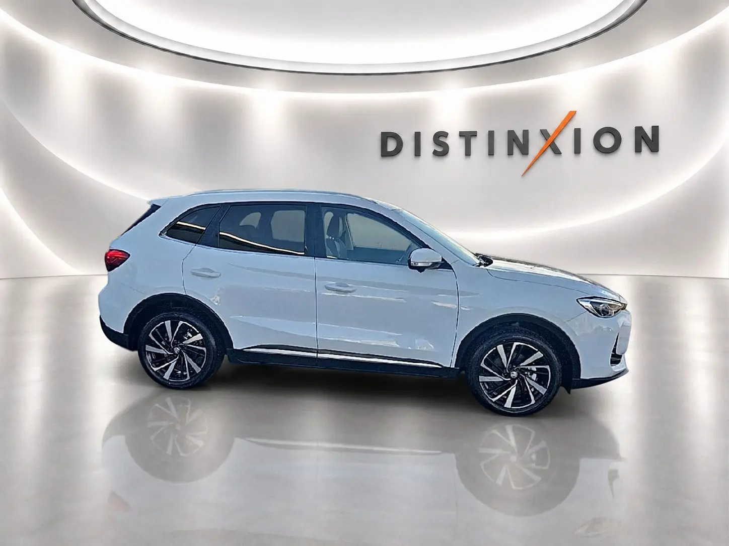 Vue de profil côté gauche d'un MG MOTOR ZS blanc 1.5 hybrid 197 luxury avec jantes alliage noires et toit panoramique.