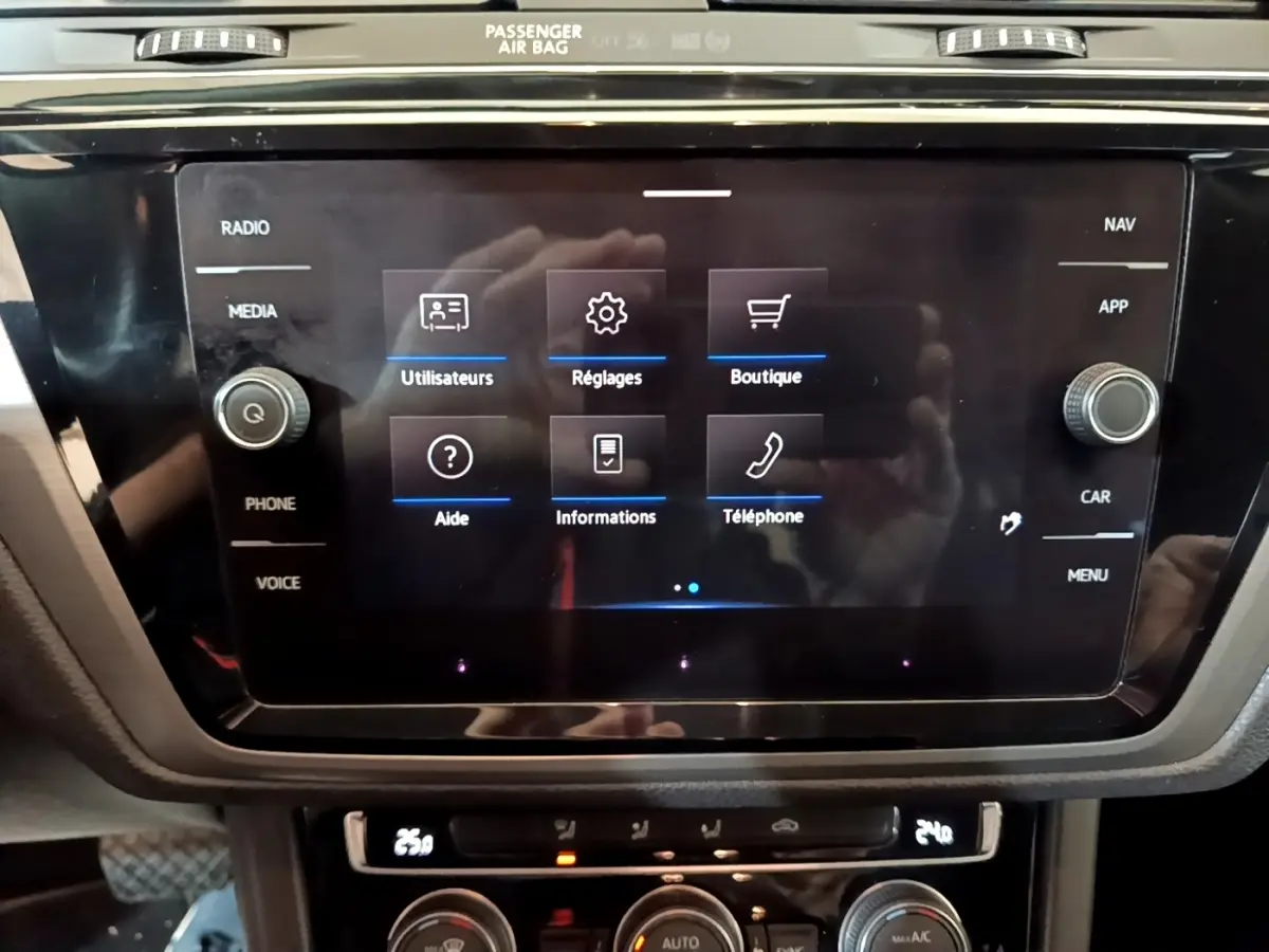 Écran tactile central du Volkswagen Touran 1.5 TSI bleu, affichant menu utilisateurs, réglages et téléphone.