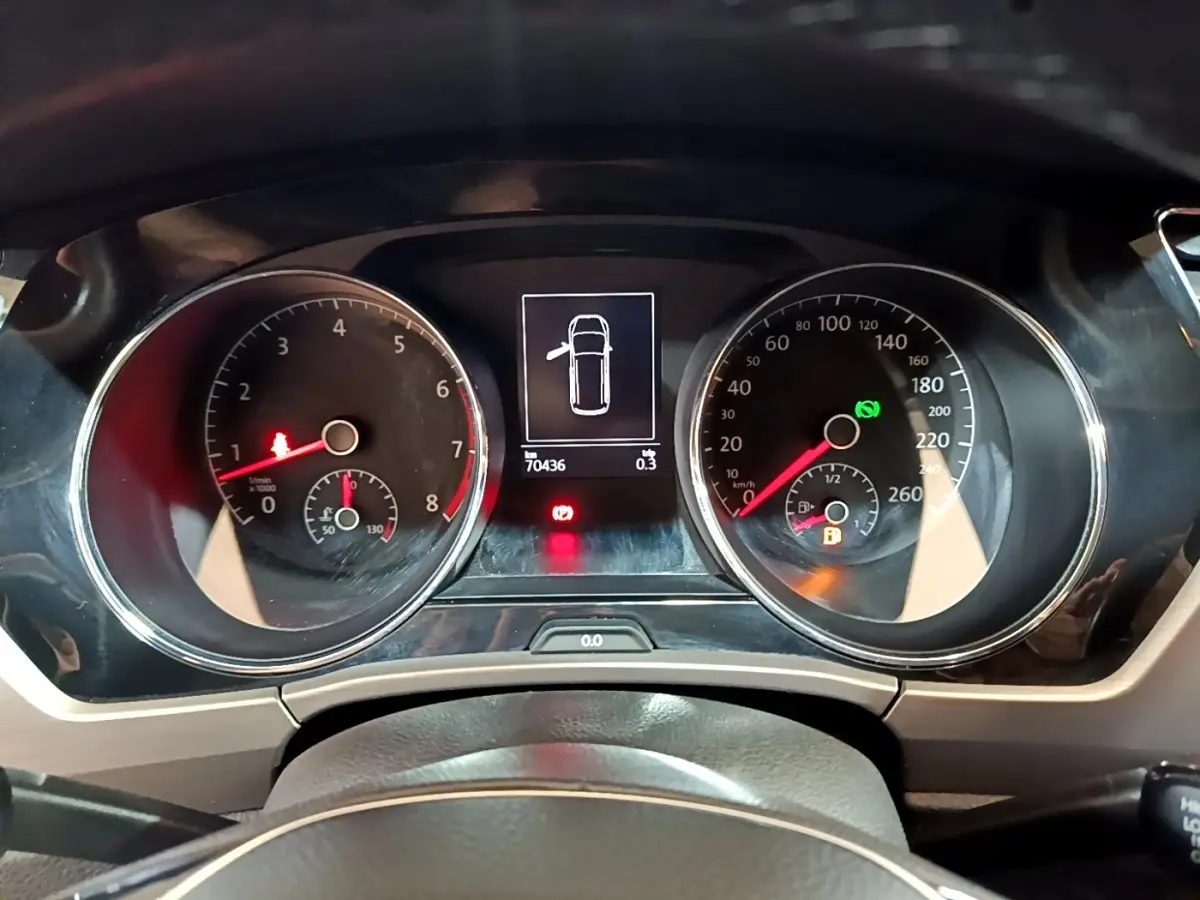 Tableau de bord du Volkswagen Touran 2021 avec compte-tours, compteur de vitesse et écran central affichant portière ouverte.