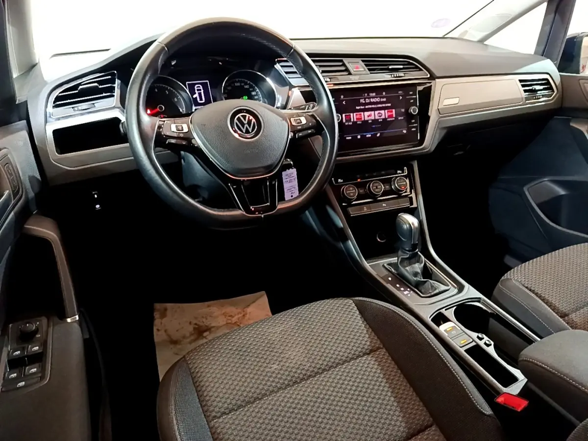 Intérieur Volkswagen Touran 1.5 TSI EVO DSG7 United 2021 vu côté conducteur, volant cuir et écran tactile central.