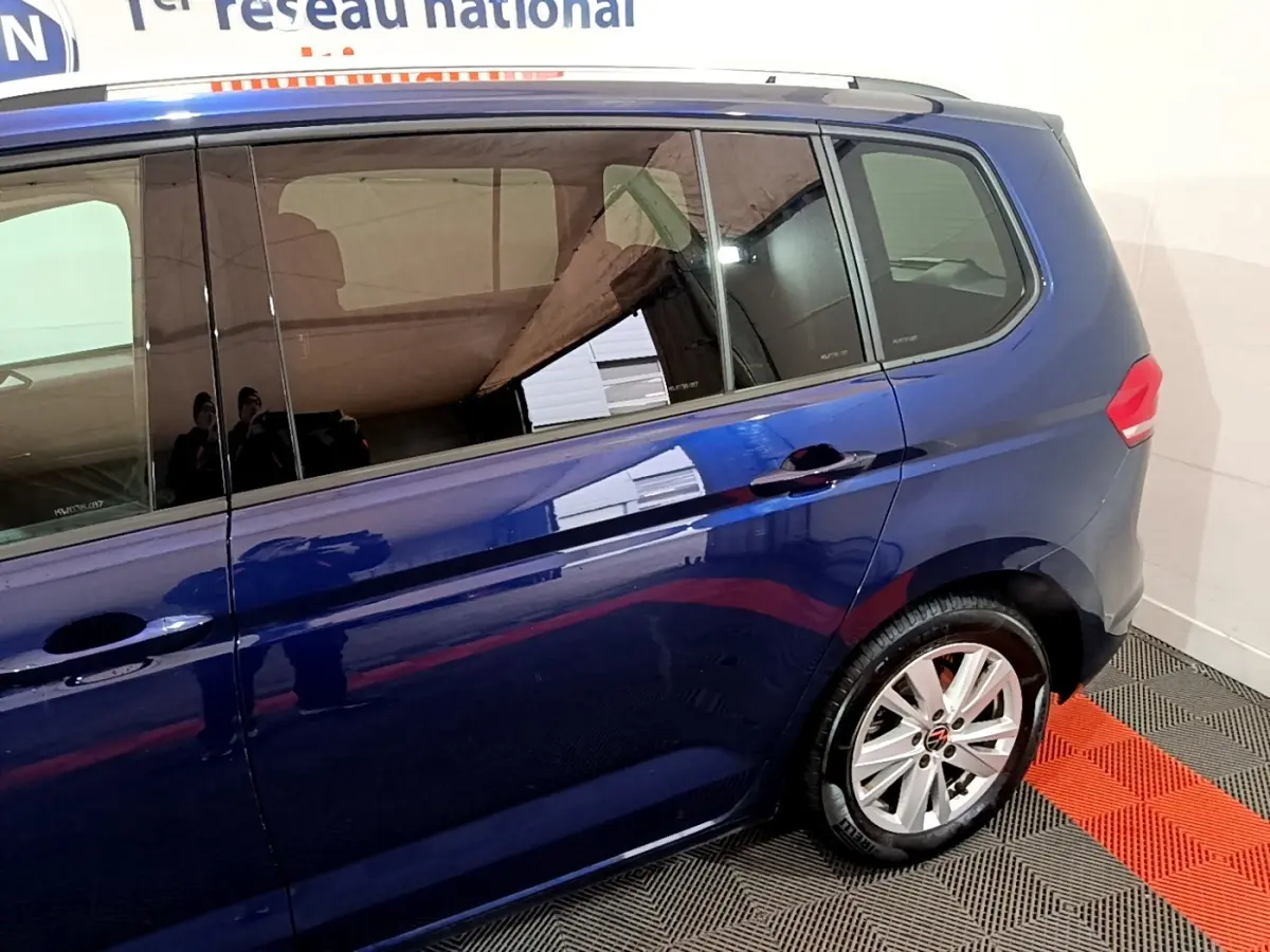 Vue latérale côté droit du Volkswagen Touran bleu 2021 avec jantes alliage et vitres teintées.