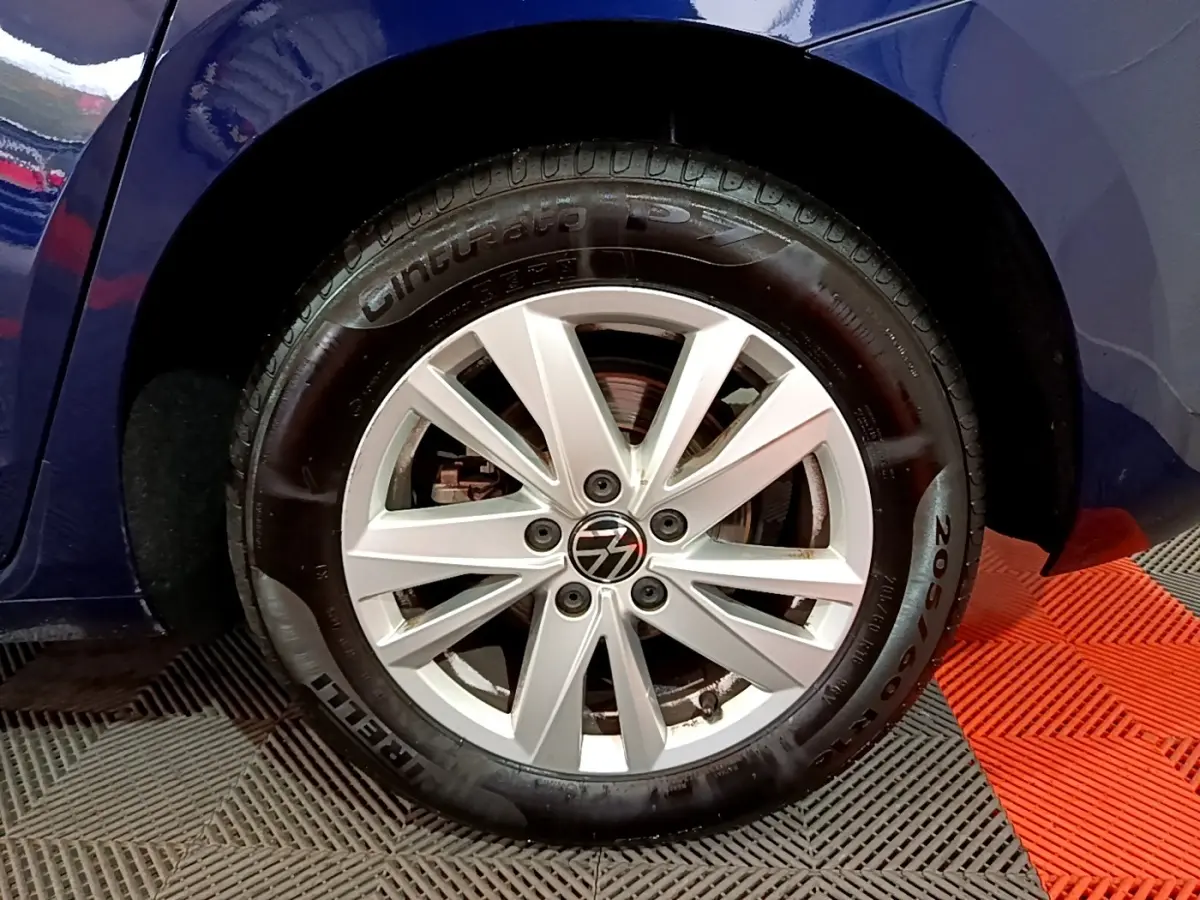 Gros plan sur la roue avant gauche du Volkswagen Touran bleu 2021, mettant en valeur la jante alliage et le pneu Pirelli.