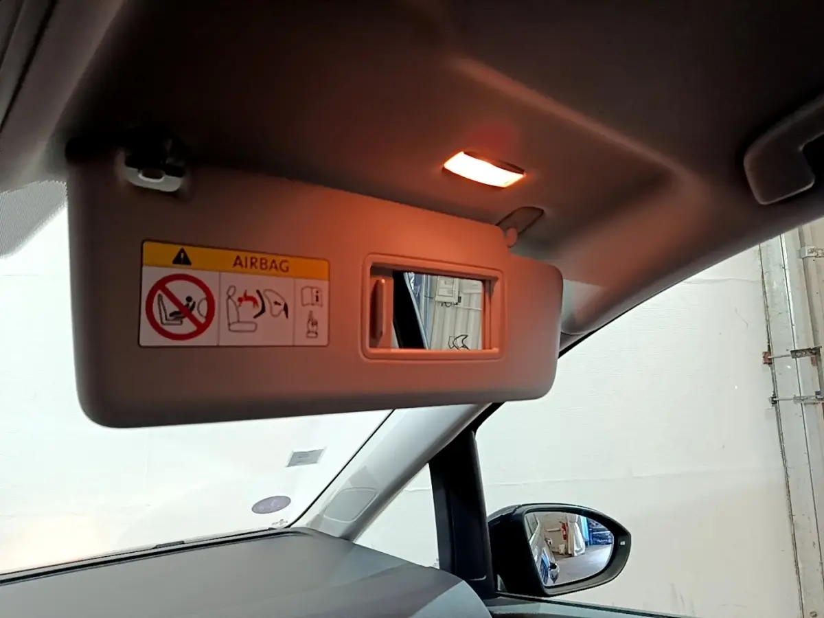 Miroir de courtoisie ouvert sur pare-soleil côté conducteur dans l’habitacle bleu du Volkswagen Touran 2021.