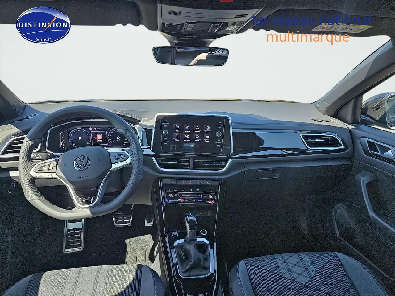 Vue intérieure avant du Volkswagen T-Roc noir perle, avec tableau de bord numérique et écran central tactile.