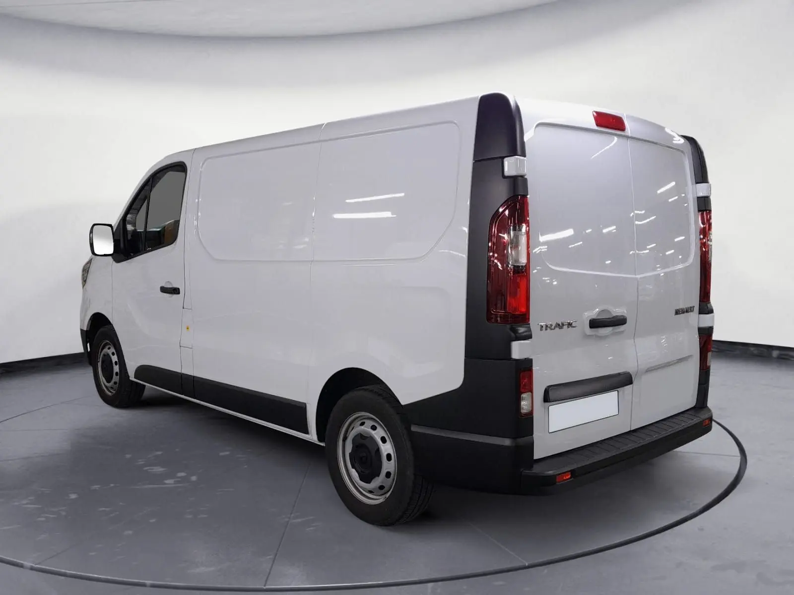 Vue 3/4 arrière droite d’un Renault Trafic Fourgon blanc 2024 avec portes arrière fermées et jantes acier.