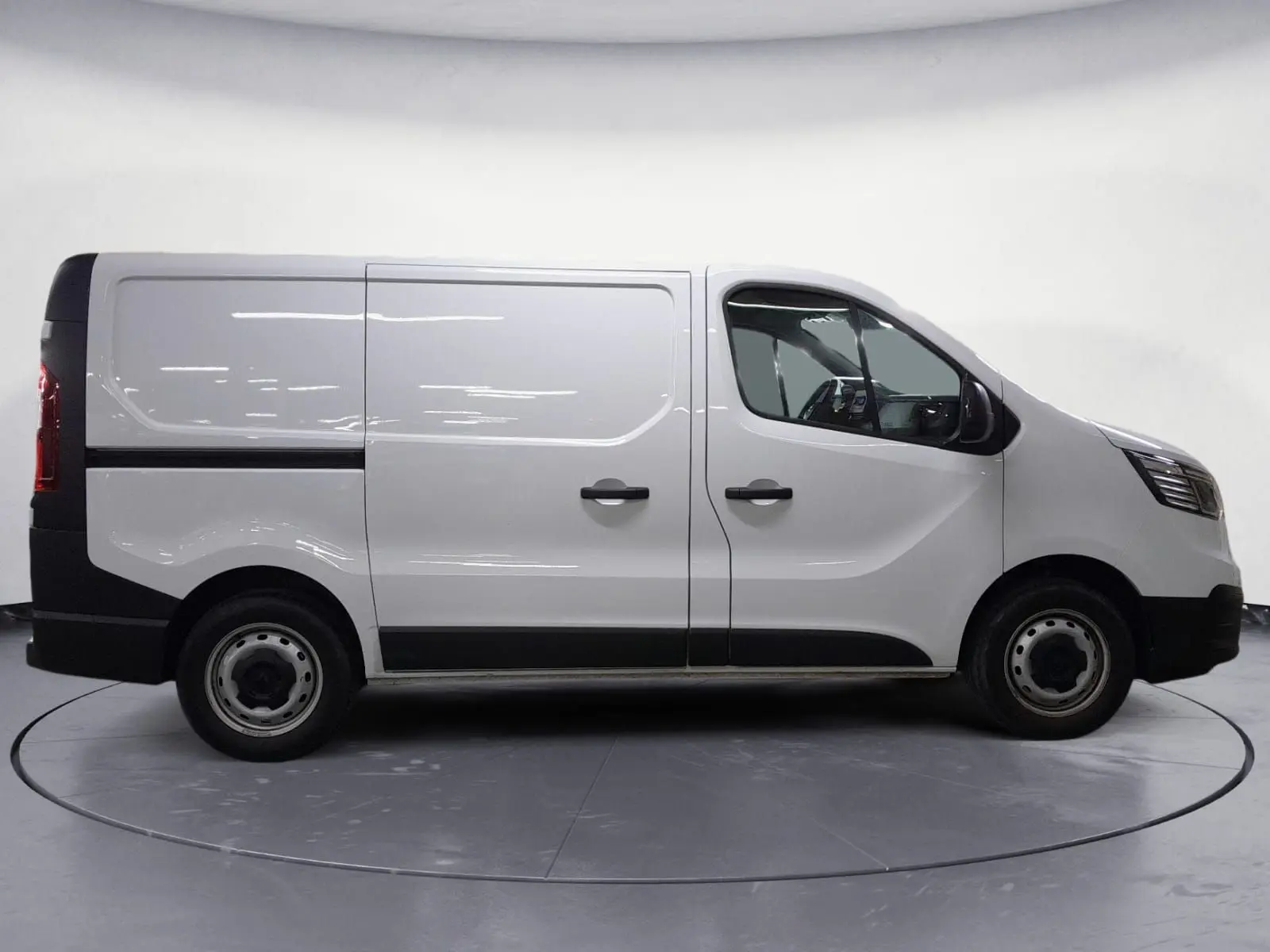 Profil droit du Renault Trafic Fourgon blanc 2024, avec portes latérales et jantes acier simples.