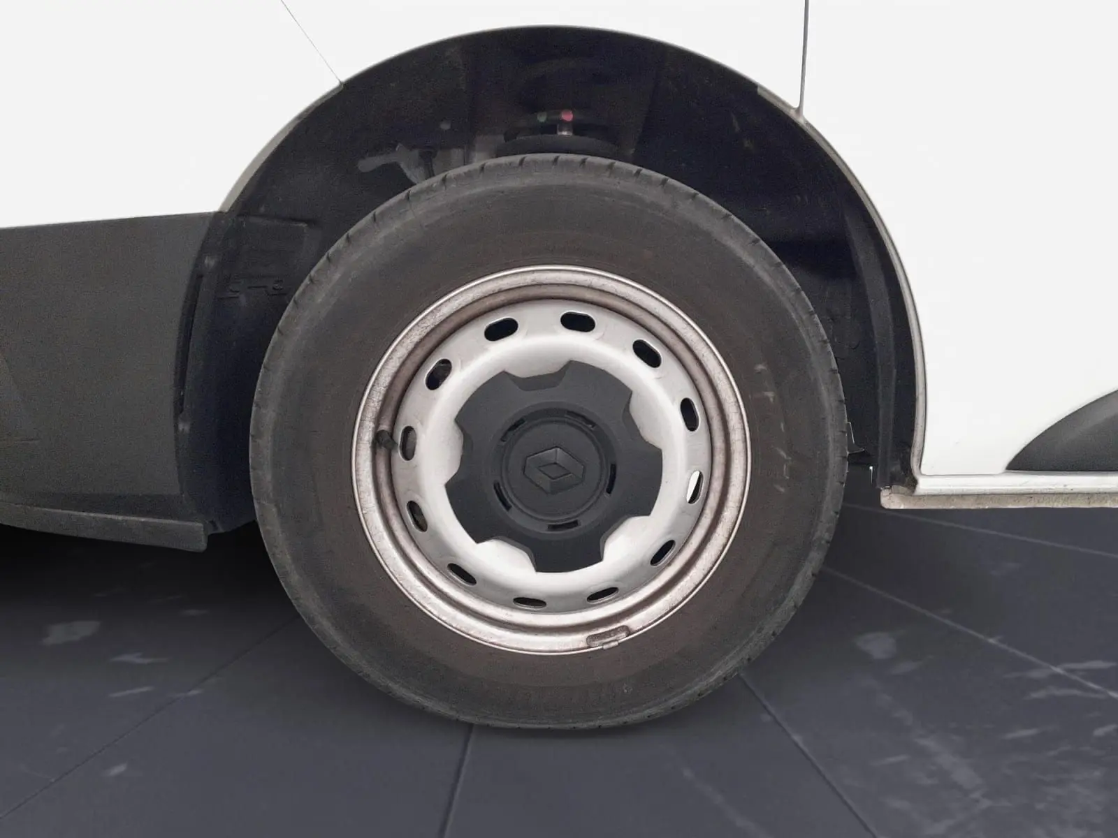 Gros plan sur la roue avant droite blanche d’un Renault Trafic Fourgon 2024 avec jante acier et logo Renault central.
