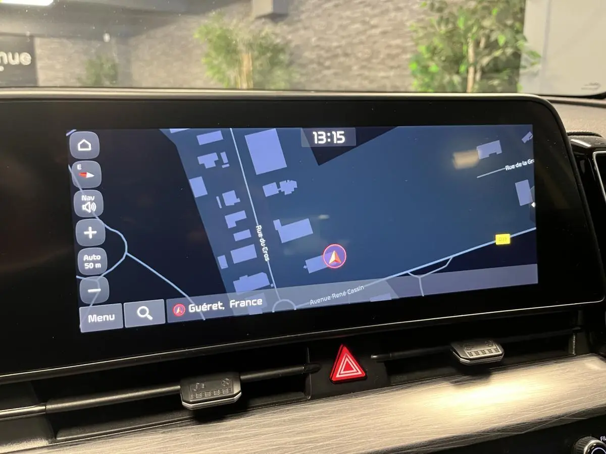 Écran tactile 12,3" du Kia Sportage 2022 affichant la navigation GPS sur fond sombre, vue intérieure avant.