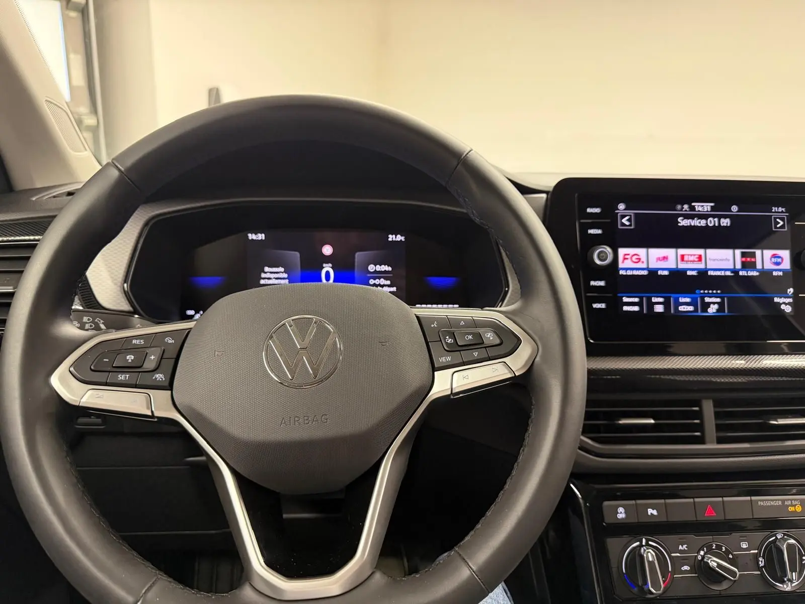 Vue intérieure centrée sur le volant et le tableau de bord numérique du Volkswagen T-Cross gris cendre 2025.