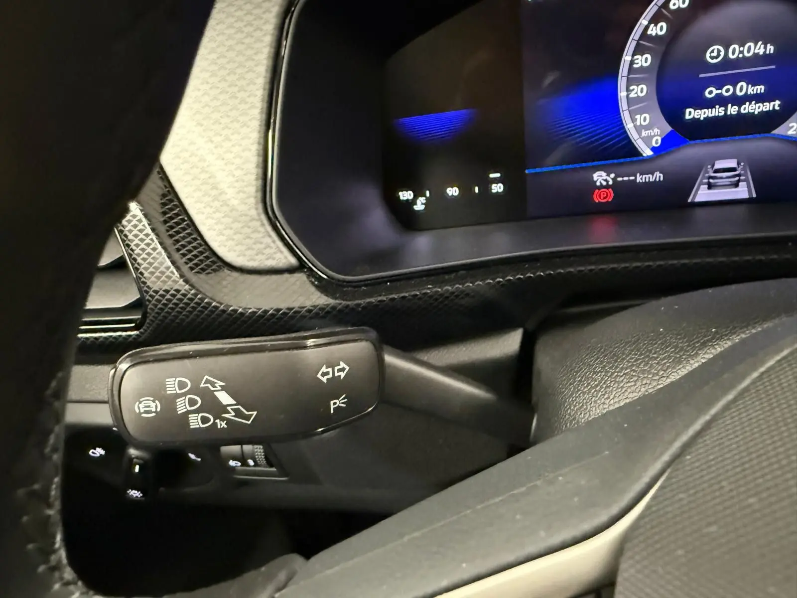 Détail du combiné d'instruments et du commodo gauche du Volkswagen T-Cross gris cendre, vue intérieure côté conducteur.